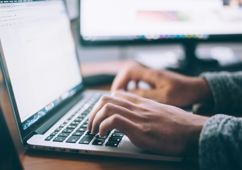 Someone writes a proposal on a laptop